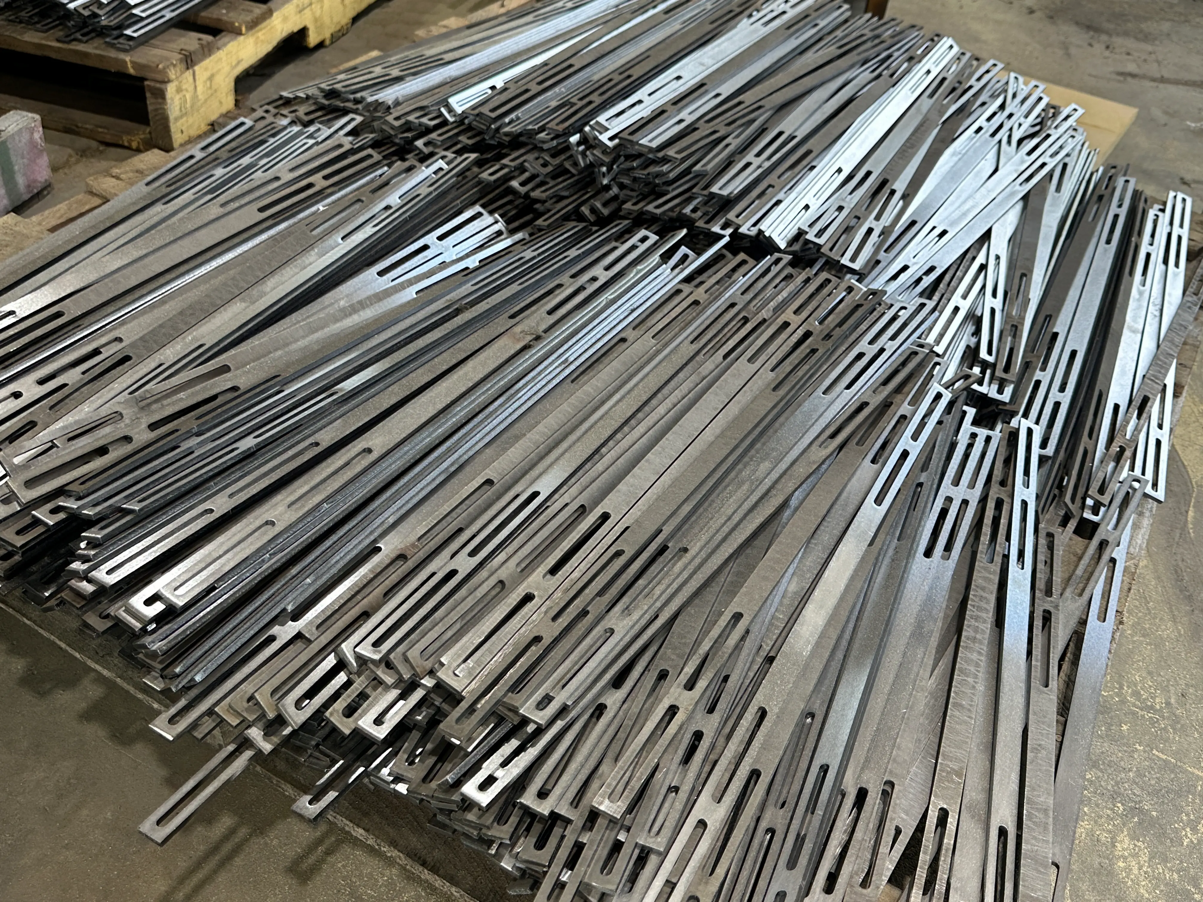 Pile of precision laser cut steel parts and components